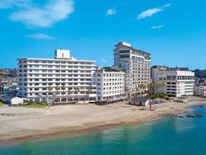 eine Gruppe von Gebäuden an einem Strand neben dem Wasser in der Unterkunft Mikazuki Sea-Park Hotel Katsuura in Katsuura