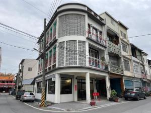 un bâtiment dans une rue avec des voitures garées devant dans l'établissement ShinYuan BNB, à Chaozhou