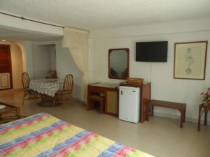 Habitación con cama, mesa y TV. en Santa Barbara Arauca en Arauca