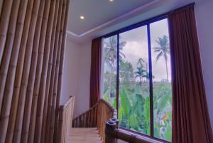 
a room with a window and a large window at Karang Lila Bhuana Ubud in Ubud
