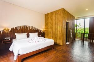 
a bedroom with a large bed and a large window at Karang Lila Bhuana Ubud in Ubud
