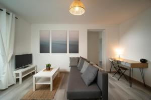 a living room with a couch and a table at Appartement tout équipé parking balcon 2 chambres in Marseille