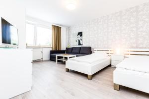 uma sala de estar com duas camas e um sofá em Cityfair Apartments Köln em Colónia