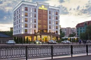 a building with cars parked in front of it at Plaza Hotel Almaty in Almaty