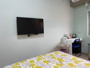 a bedroom with a flat screen tv on the wall at ShinYuan BNB in Chaozhou