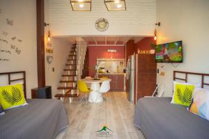 Habitación con 2 camas y cocina con mesa. en Cabañas Sublime Bolsón en El Bolsón