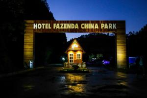 un edificio bajo un cartel que lee Hotel Lagenda China Park en Hotel Fazenda China Park en Pedra Azul