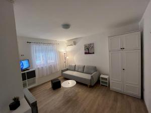 uma sala de estar com um sofá e uma mesa em Apartments Matija - 30m from sea em Jezera