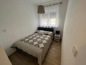 um pequeno quarto com uma cama e uma janela em Apartments Matija - 30m from sea em Jezera