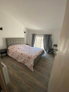 een slaapkamer met een bed en een groot raam bij Douceur occitane in Saint-Chinian
