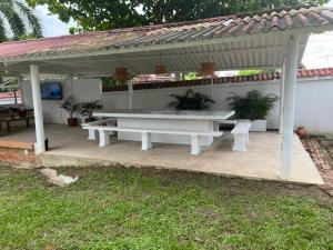 a white picnic table under a pavilion in a yard at Villa Tarek in Carmen de Apicalá