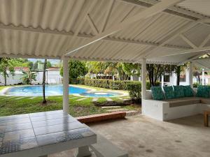 a pavilion with a couch and a table and a pool at Villa Tarek in Carmen de Apicalá