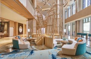 a lobby with couches and tables and a chandelier at Holiday Inn Resort Ho Tram Beach by IHG in Ho Tram +37 photos