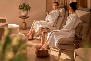 two women in robes sitting in chairs in a living room at Holiday Inn Resort Ho Tram Beach by IHG in Ho Tram