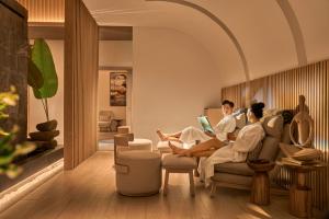 two people sitting on a couch in a living room at Holiday Inn Resort Ho Tram Beach by IHG in Ho Tram