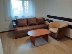 a living room with a couch and a chair and a table at Zhaylau Hotel in Shchūchīnsk