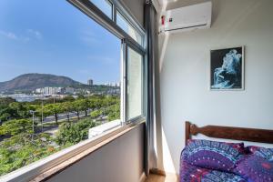 a bedroom with a window with a view of the city at Charmoso Apartamento na Praia de Botafogo in Rio de Janeiro