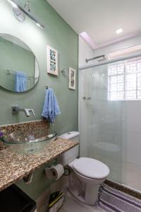 a bathroom with a sink and a toilet and a shower at Charmoso Apartamento na Praia de Botafogo in Rio de Janeiro
