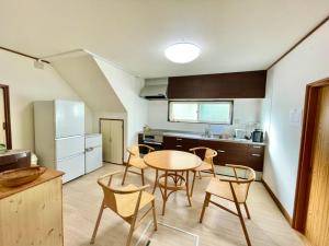 een keuken met een tafel en stoelen in een kamer bij Holiday House Toya in Lake Toya