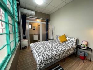 潮州鎮的住宿－欣園小筑民宿，一间小卧室,配有床和黄色枕头
