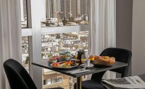 a table with food on it in front of a window at Vital - Urban boutique hotel TLV in Tel Aviv +24 photos