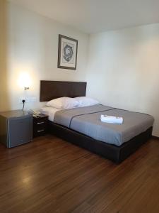 a bedroom with a bed and a nightstand with a bed sidx sidx at SO Hotel in George Town