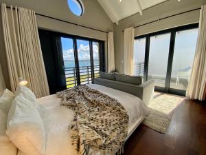 a bedroom with a bed and a view of the ocean at TH39 Thesen Islands in Knysna