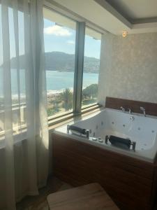 a bathroom with a tub with a large window at Wien Star Hotel in Alanya