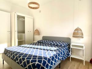 a bedroom with a bed with a blue and white comforter at Naked House Sardinia in Bari Sardo