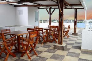a restaurant with wooden tables and chairs on a checkered floor at Hotel Jardines del Caney in Cali