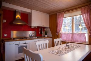 a kitchen with a table and chairs in a room at Trollforsen Camping & Cottages in Gargnäs