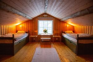 um pequeno quarto com 2 camas e uma janela em Trollforsen Camping & Cottages em Gargnäs