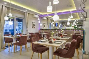 un restaurante con mesas, sillas y luces en Madison Luxury Apartments & Rooms en Zagreb