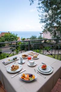 a table with plates of food on a balcony at Hotel Martino in Maratea