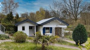 een klein wit huis met een blauwe deur bij Ferienhaus Seepferdchen in Göhren