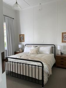 una camera da letto con un grande letto e pareti bianche di The Country House Maffra a Maffra