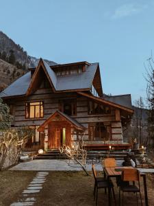 a log cabin with a table in front of it at SaffronStays The Amlyn, Manali - unobstructed views of Beas river and the Himalayas in Manāli