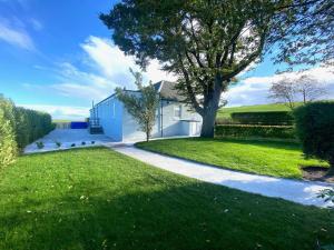 a white house with a tree and a driveway at The Old Toll House in St. Andrews