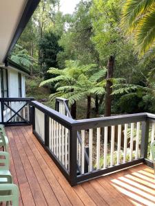 a wooden deck with chairs and trees on a house at Grey Gum Getaway Tecoma in Belgrave