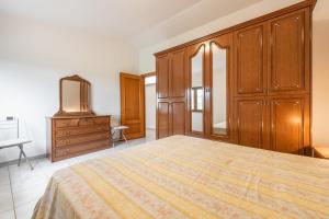 a bedroom with a large bed and a dresser at Casa Colonia 3 in SantʼAnna Arresi