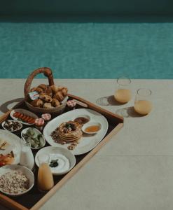 una bandeja de comida en una mesa con dos vasos de zumo de naranja en Seven Rocks en Palioúrion