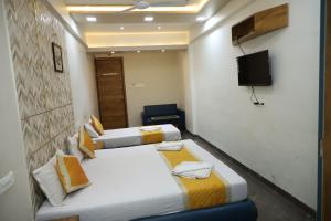 a room with three beds and a television in it at Hotel Dolphin Residency in Pātan
