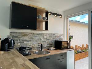 a kitchen counter with a sink and a window at Le Studio de l'Olivier in Courcelles-sur-Seine