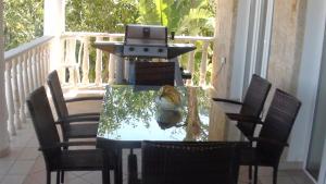 a table with a grill on a porch with chairs at Pomos Harbourbiew Villa in Pomos
