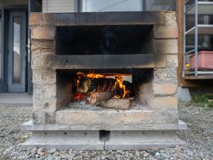 a brick oven with a fire in it at Five Peaks Jigokudani in Shiga Kogen