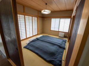 ein kleines Zimmer mit einem Bett in der Ecke in der Unterkunft Five Peaks Jigokudani in Shiga Kogen