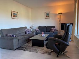 sala de estar con sofá y silla en Haus Bergzicht en Schwalefeld