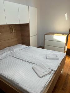 1 dormitorio con 1 cama con sábanas blancas y armarios blancos en Free Terrace en Piran