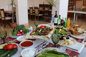 uma mesa coberta com pratos de alimentos e produtos hortícolas em Diligence Hotel & restaurant em Dilijan