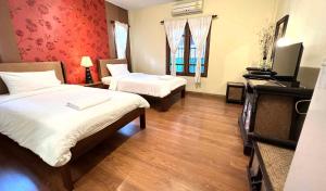 a hotel room with two beds and a television at Plumeriahome near Walking Street in Chiang Mai